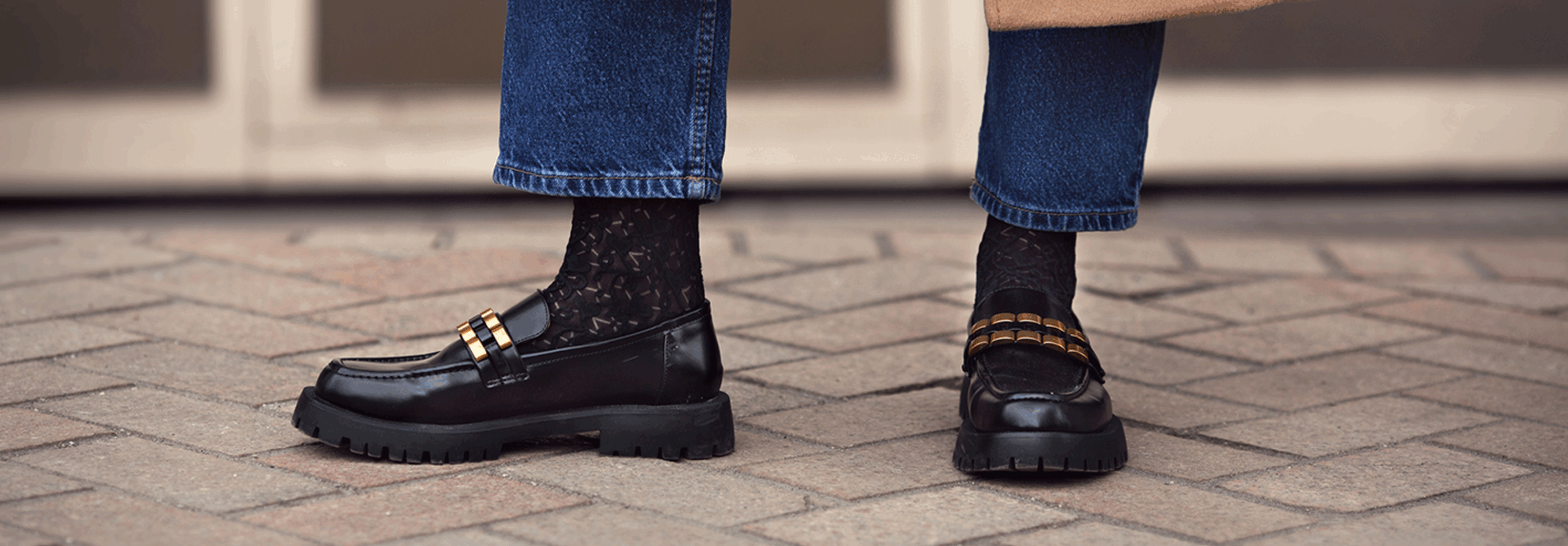 Two people one laughing with closed eyes and the other smiling share a joyful moment together indoors.